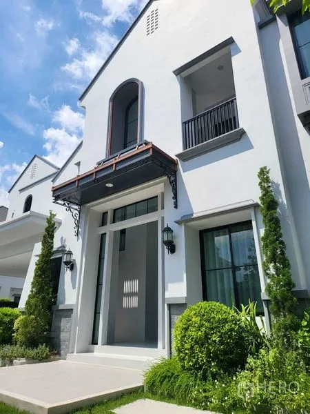 Detached House for rent in Saphan Sung, Bangkok - Close-up of the house entrance with tall arched window and small balcony.
