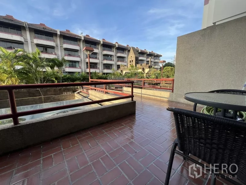 Townhouse for rent or sale in Suan Luang, Bangkok - Spacious terrace with red railings overlooking a low‑rise courtyard and greenery.