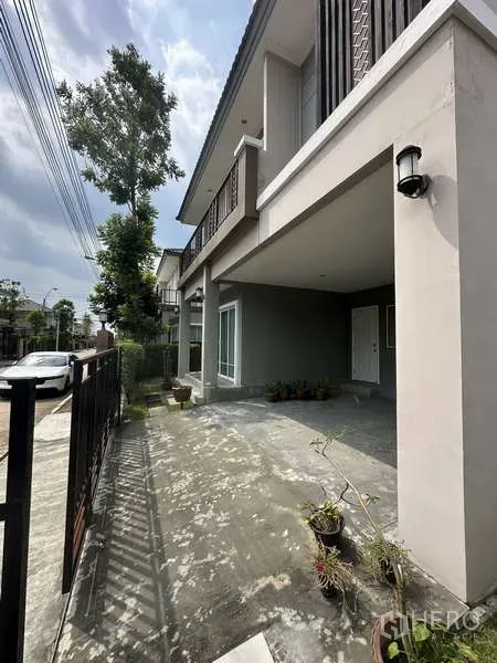 Detached House for sale in Sai Mai, Bangkok - Covered driveway and front patio area behind the metal gate.