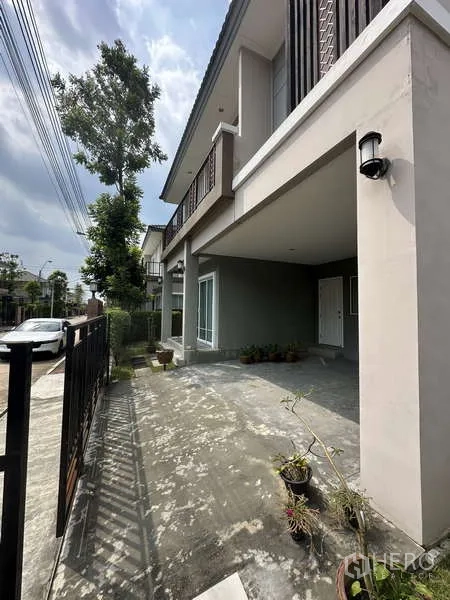 Detached House for sale in Sai Mai, Bangkok - Covered driveway and front patio area behind the metal gate.