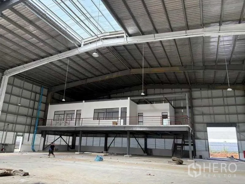 Factory for rent in Rayong - Mezzanine office block inside the factory with stairs under an arched steel roof.