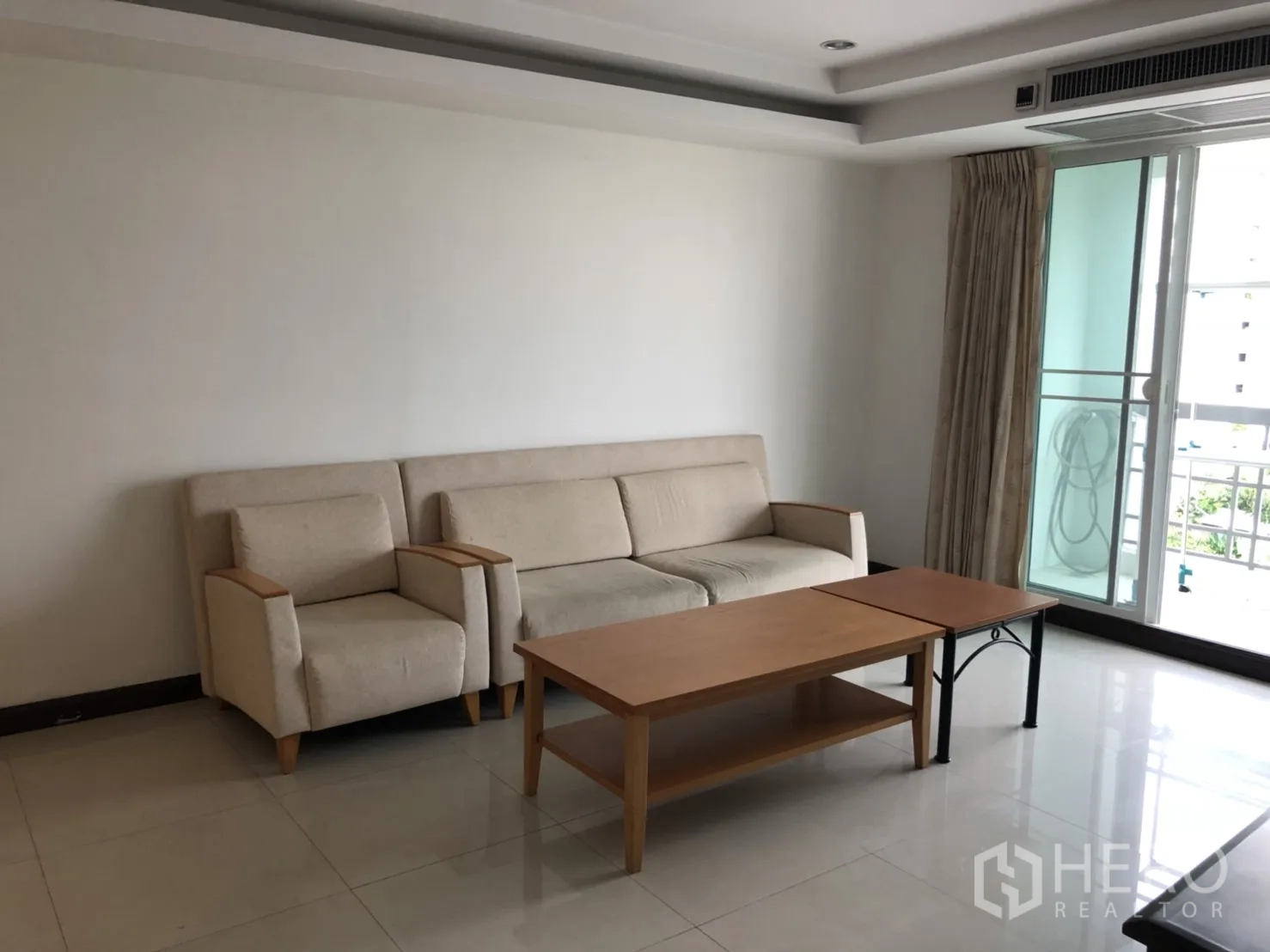 Condominium for rent in Watthana, Bangkok - Compact sitting area with sofa and coffee table near the balcony.