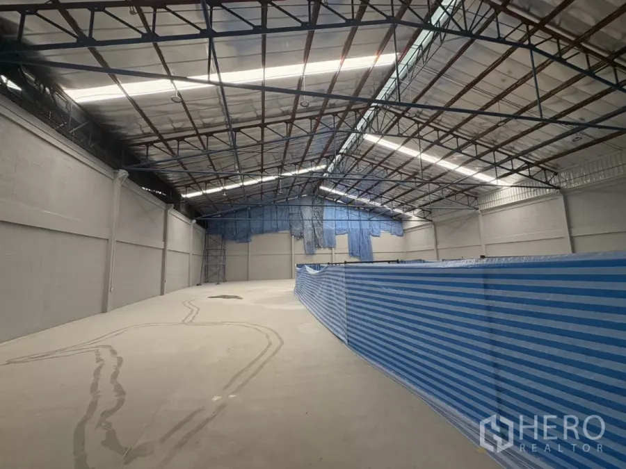 Factory for rent in Bang Phli, Samut Prakan - Spacious warehouse interior with high steel truss roof, skylight panels, and polished concrete floor.