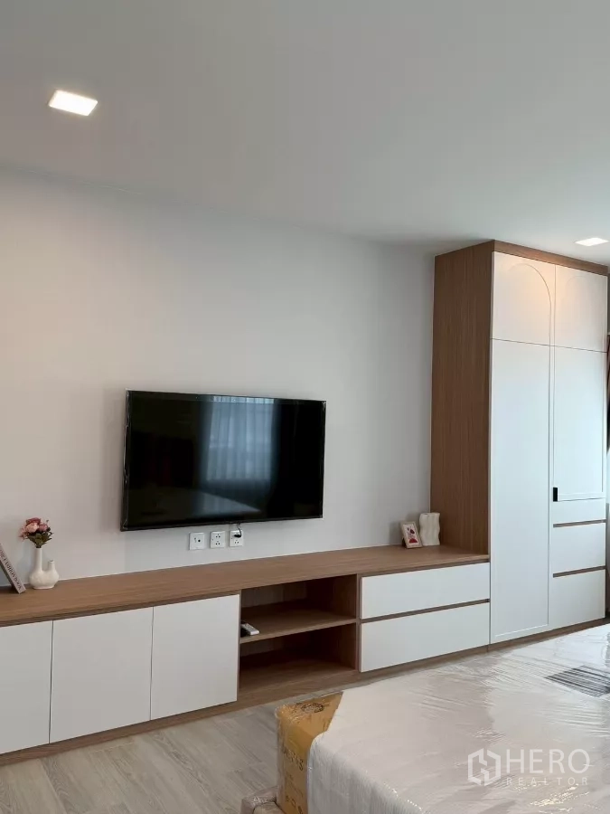 Detached House for rent in Bang Phli, Samut Prakan - Master bedroom wall-mounted TV with low cabinets and built-in wardrobe detail