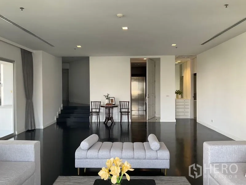 Apartment for rent in Sathon, Bangkok - Large foyer and sitting area with dark wood floors and a staircase.
