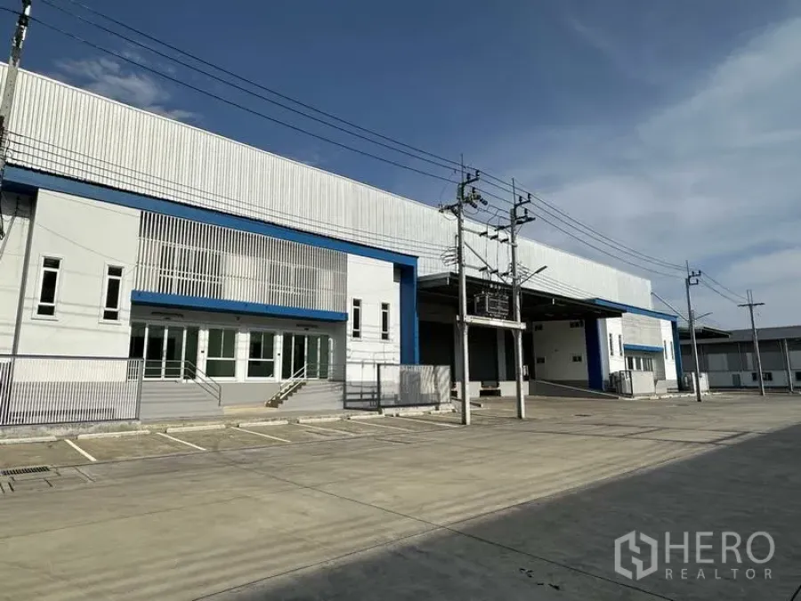 Factory for rent in Bang Sao Thong, Samut Prakan - Modern factory facade in Bang Sao Thong with wide concrete yard, parking, and covered loading bays.