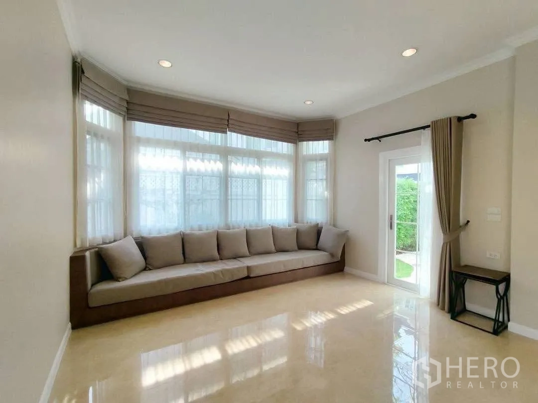 บ้านเดี่ยว for rent in Bang Na, Bangkok - ห้องนั่งเล่นสว่าง โซฟาบิลท์อินยาว และประตูออกสวน