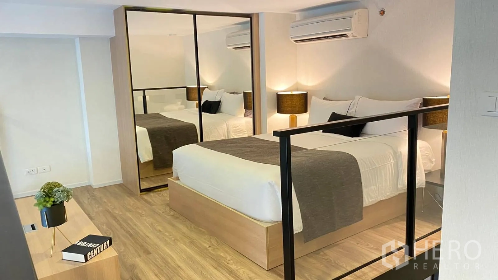 Condominium for rent or sale in Khlong Toei, Bangkok - Mezzanine bedroom with double bed, mirrored wardrobe, and glass railing.