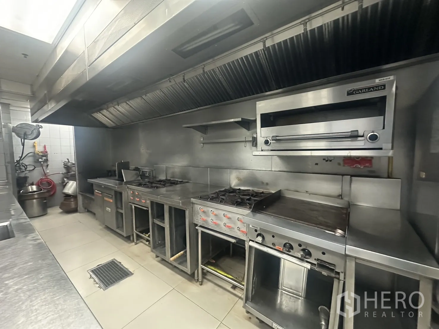 Retail Space for rent in Khlong Toei, Bangkok - Professional kitchen with gas stoves, oven and large exhaust hoods.