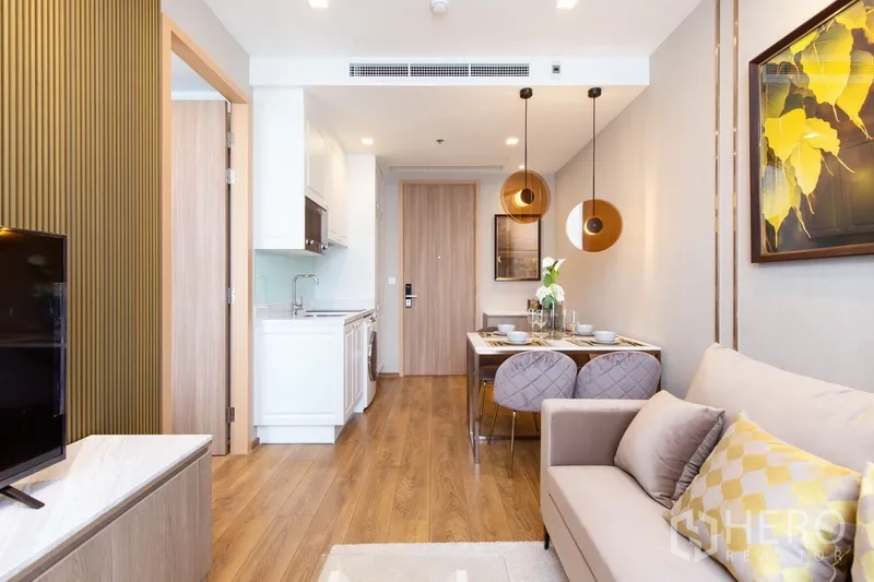 公寓 出租在Watthana, Bangkok - 从客厅望向厨房与餐桌，木地板与暖色灯光