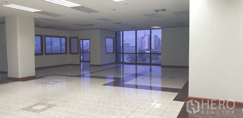 Office Space for rent in Din Daeng, Bangkok - Corner office area with panoramic glazing, skyline outlook, and suspended fluorescent lighting.