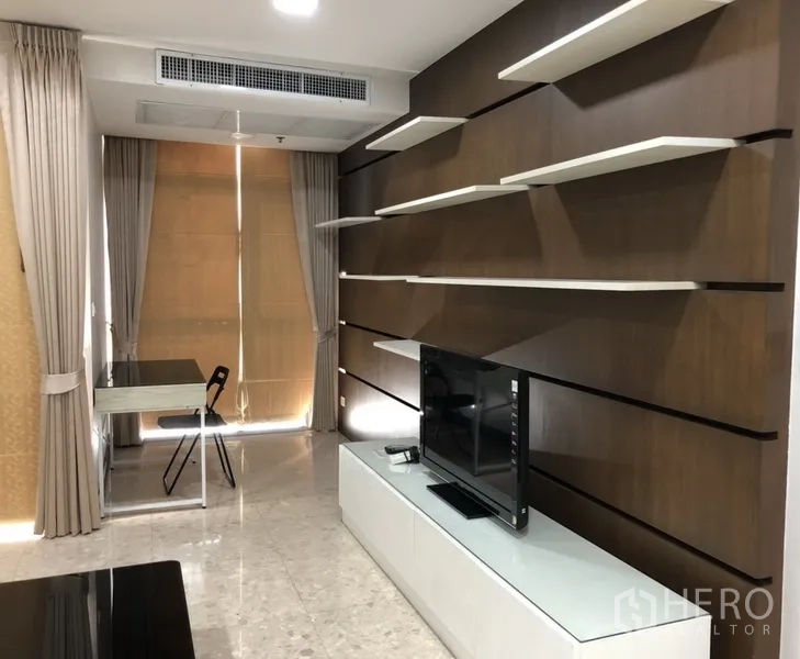 公寓 出租在Khlong Toei, Bangkok - 电视墙配悬空隔板、电视柜、书桌与高窗帘。