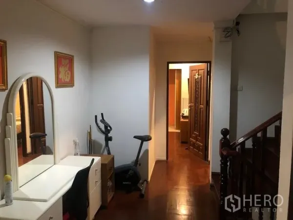 Retail Space for rent in Khlong Toei, Bangkok - Upper hallway with wooden flooring, vanity desk, exercise bike and staircase.