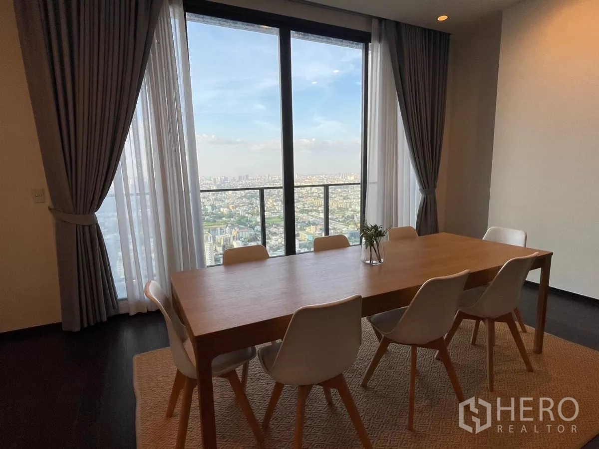 Condominium for rent in Phra Khanong, Bangkok - Dining room close-up showing skyline through sliding doors and a private balcony.