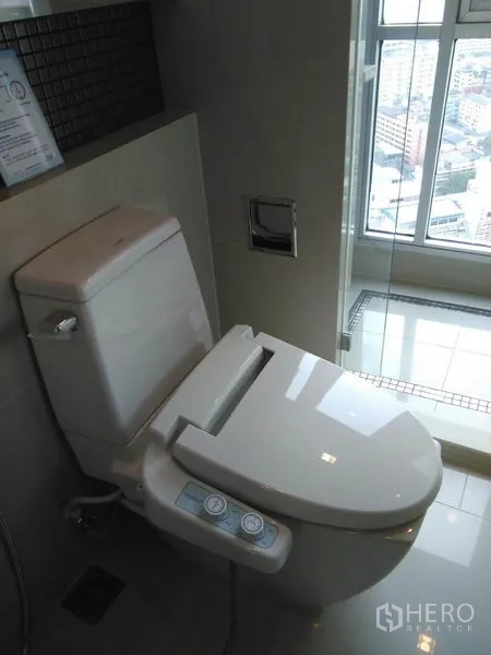 Condominium for rent in Sathon, Bangkok - Contemporary bathroom with smart bidet toilet and a glass shower with city view.