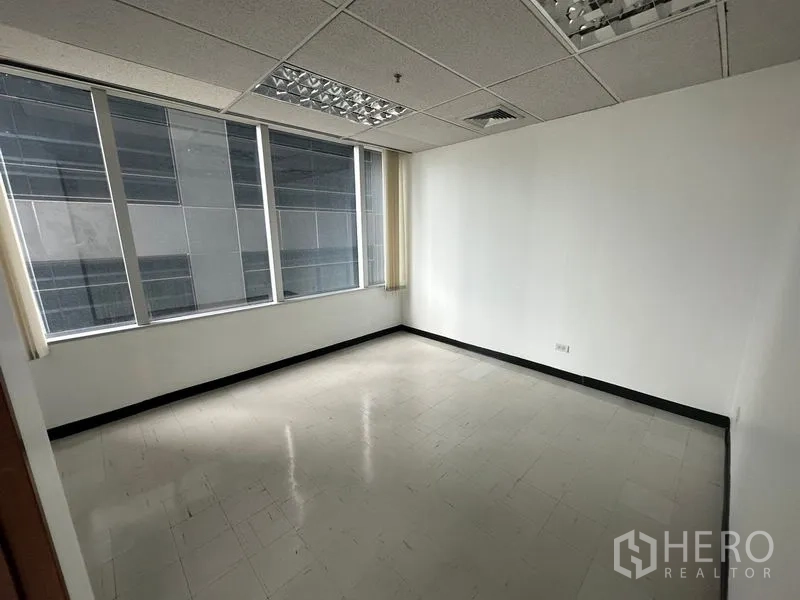 Office Space for rent in Chatuchak, Bangkok - Private office room with a large window facing a neighboring tower.