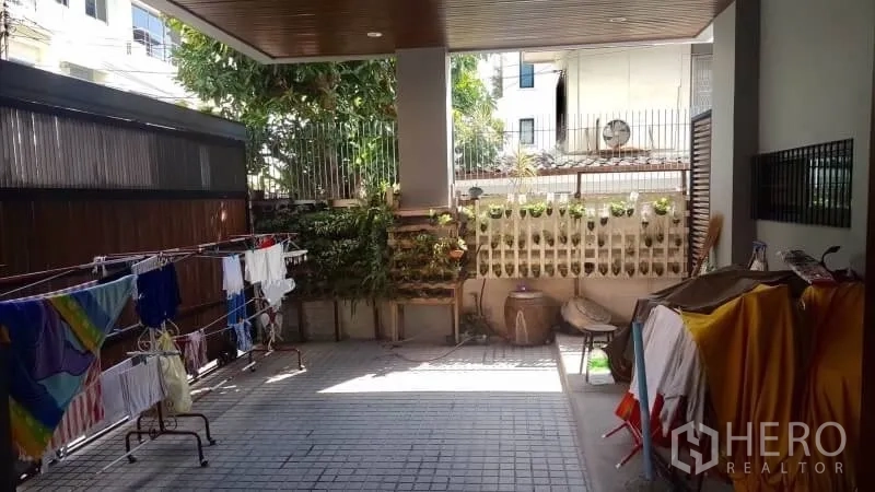 Home Office for rent or sale in Bang Rak, Bangkok - Covered patio or carport used as a laundry area with clothes racks and potted plants.
