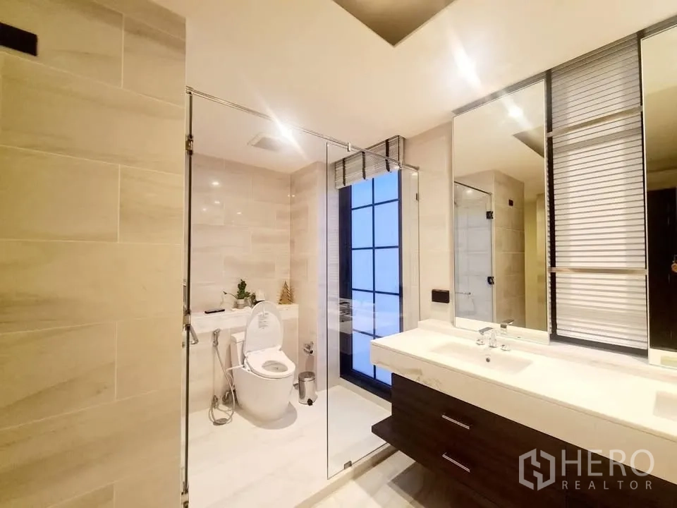 ทาวน์เฮาส์ for rent or sale in Watthana, Bangkok - ห้องน้ำสไตล์โมเดิร์นพร้อมฉากกั้นกระจก โถสุขภัณฑ์ และกระจกบานใหญ่