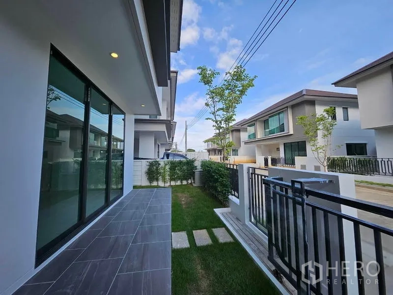 Detached House for rent in Saphan Sung, Bangkok - Side terrace with sliding glass doors opening to a small lawn and fenced garden.