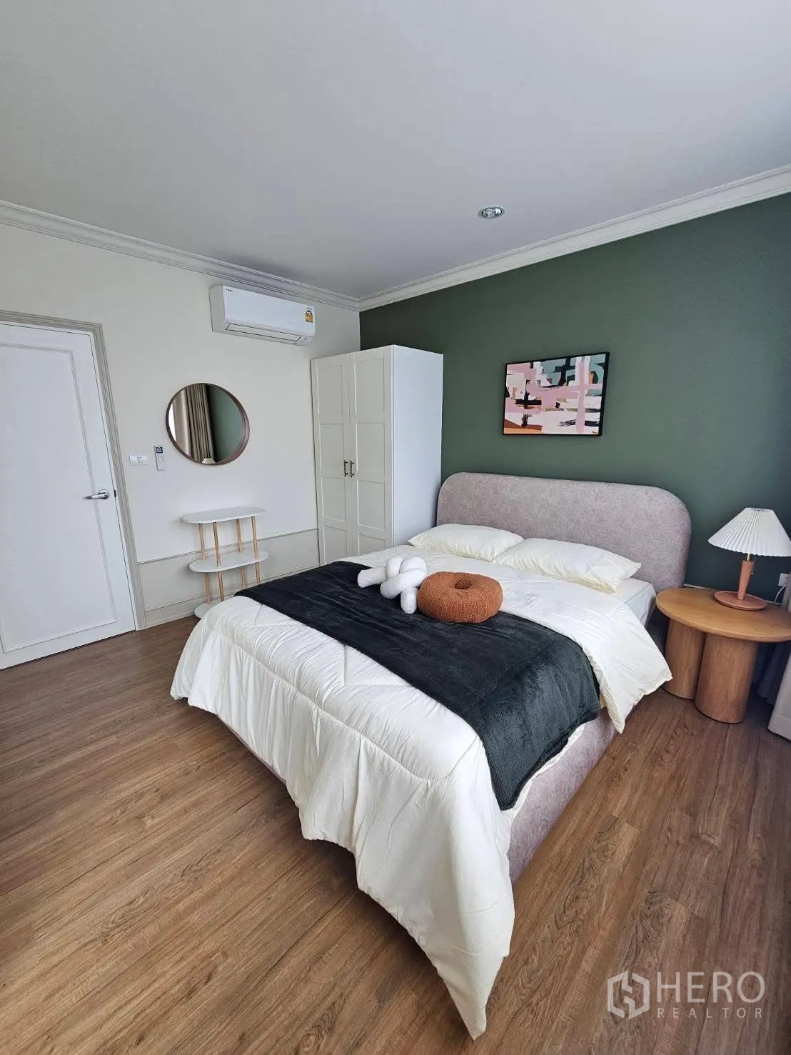 Townhouse for rent in Saphan Sung, Bangkok - Secondary bedroom with green accent wall, upholstered bed, wardrobe, and round bedside table.