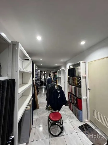 Retail Space for rent in Khlong Toei, Bangkok - Narrow retail corridor with built-in shelving, tiled floor and recessed LED lighting.