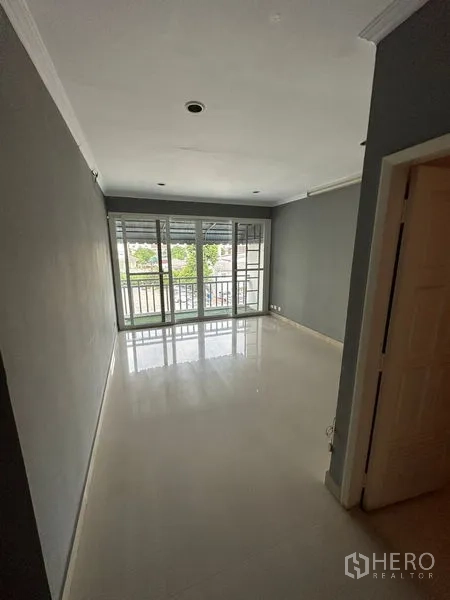 Townhouse for rent in Bang Kapi, Bangkok - Bedroom with glossy floor and sliding glass doors opening to a balcony.