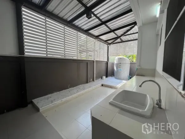Detached House for rent or sale in Bang Phli, Samut Prakan - Covered service area with tiled floor, utility sink and louvered privacy panels.