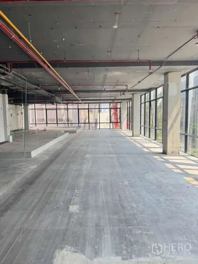Retail Space for rent in Bang Rak, Bangkok - Large shell retail space with floor-to-ceiling windows and exposed ceiling services.