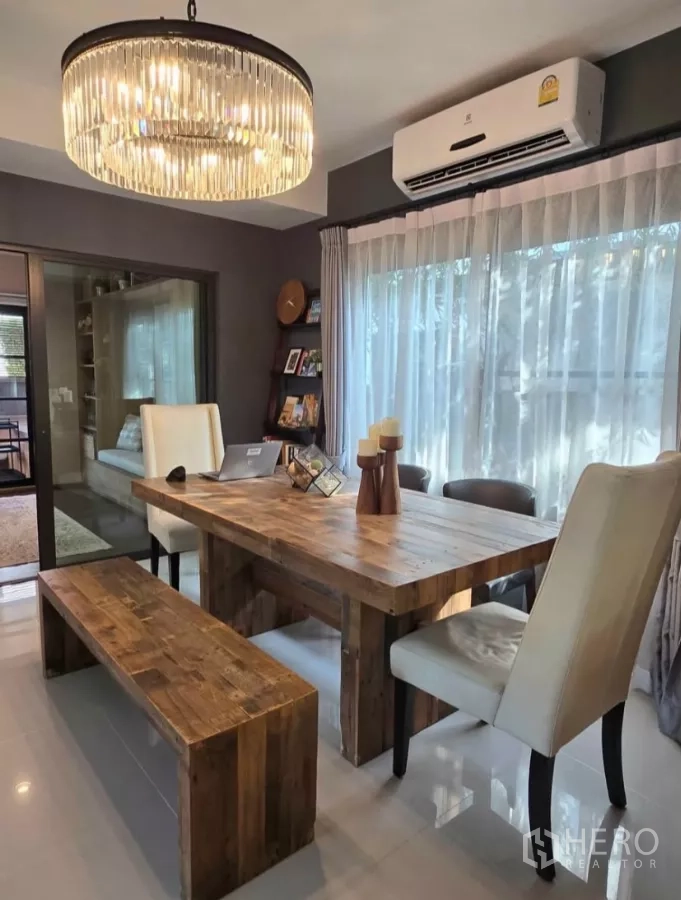 Detached House for rent in Bang Phli, Samut Prakan - Close-up of rustic wooden dining table with bench and white chairs under chandelier