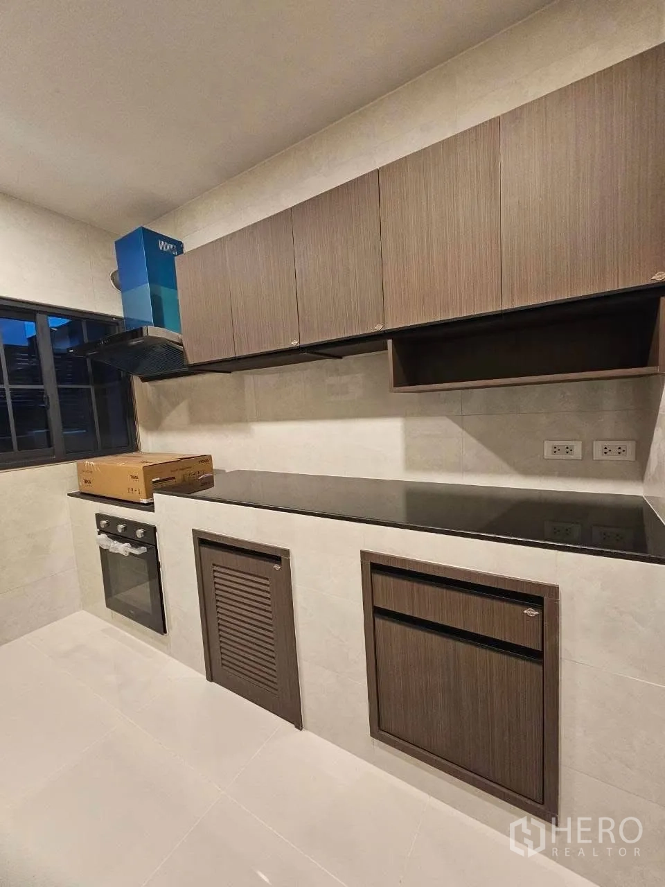 Detached House for rent or sale in Bang Phli, Samut Prakan - Close-up of kitchen cabinetry with long counter and window.