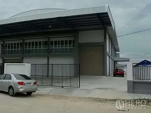Warehouse for rent in Bang Bo, Samut Prakan - Front facade of the industrial warehouse with secure black gates and parking area.