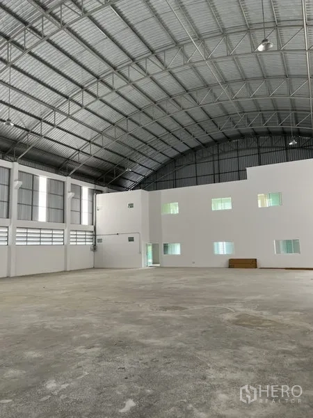 工厂 出租或出售在Bang Bo, Samut Prakan - 宽阔仓库地面，面向内部办公室夹层与高耸屋架。