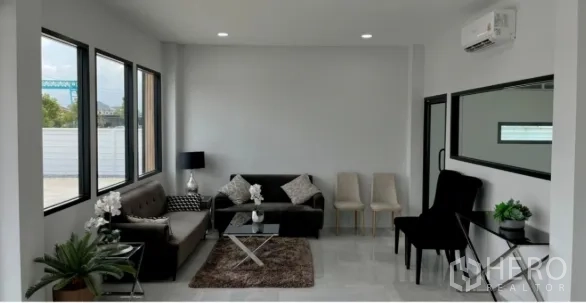 Warehouse for sale in Bang Bua Thong, Nonthaburi - Air-conditioned office lounge with sofas, chairs, large windows and a glass partition.