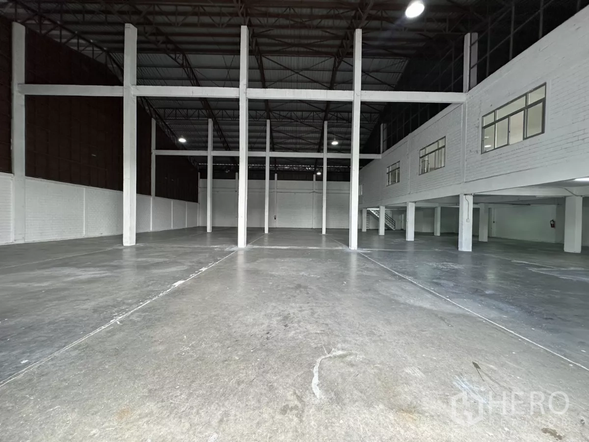 Warehouse for rent in Phra Khanong, Bangkok - Warehouse bay featuring a mezzanine-style office block with windows and internal staircase.