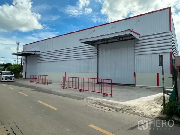 货栈 出租在Don Mueang, Bangkok - 仓库正面视角，超宽卷闸门与封闭车道便于卡车进出。