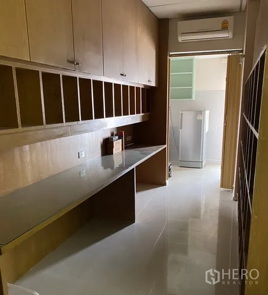办公空间 出租在Din Daeng, Bangkok - 长走道式储物区，内置木柜与玻璃台面，通往茶水间