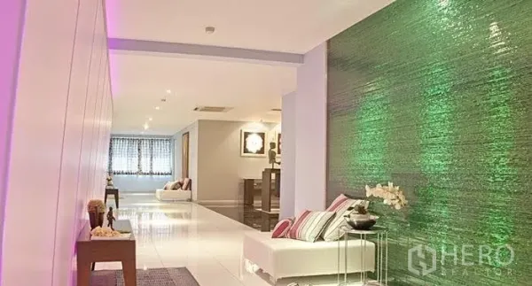 Condominium for rent in Yan Nawa, Bangkok - Hallway with an illuminated green feature wall, accent lighting and lounge seating.