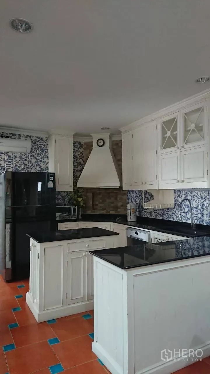 Detached House for rent in Mueang Samut Prakan, Samut Prakan - Western kitchen with white cabinetry, black stone countertops and a center island.