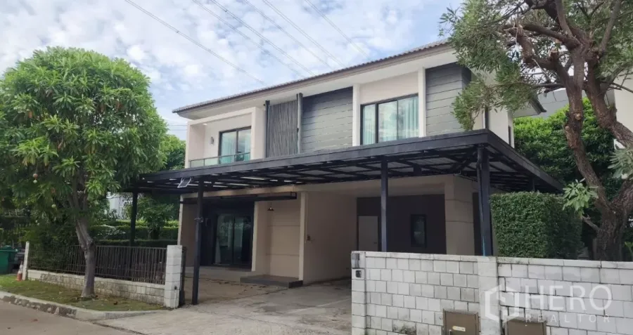 独立式住宅 出租在Samut Prakan - 转角地两层独栋别墅，带遮雨车棚与成熟绿树。