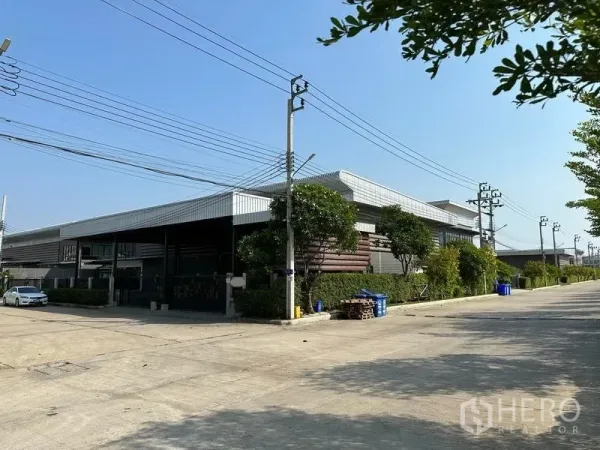 Factory for rent in Samut Prakan - Modern factory building with gated frontage on a wide industrial road in Bang Bo.