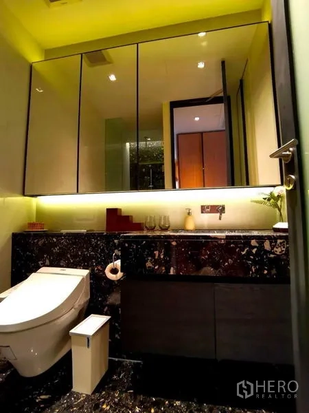 Condominium for rent in Khlong Toei, Bangkok - Contemporary bathroom with illuminated mirror, marble vanity, and smart toilet.
