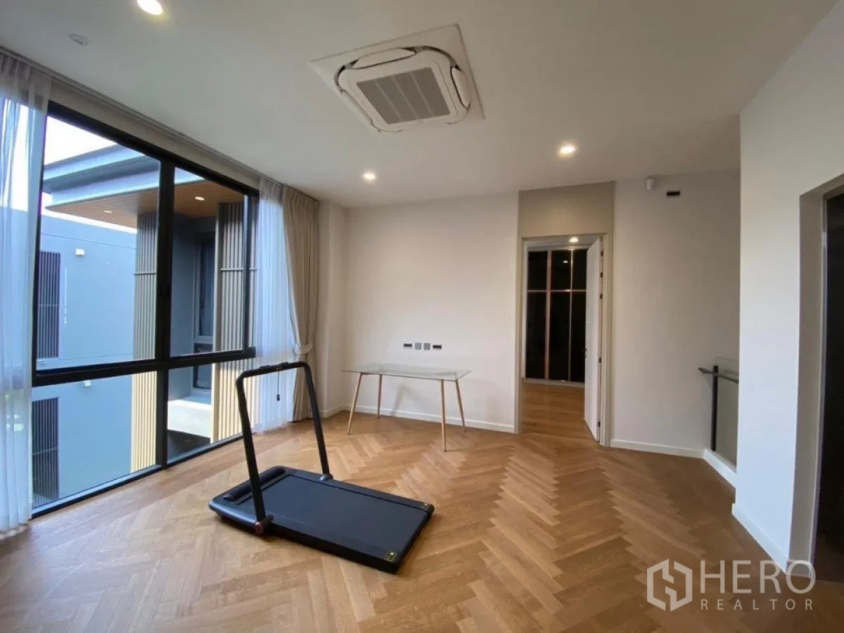 Detached House for rent in Wang Thonglang, Bangkok - Upper-floor flex room with herringbone wood floor and large windows.