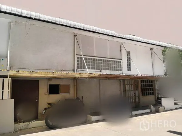 零售空间 出租在Khlong Toei, Bangkok - 两层商业建筑外观，带雨棚与玻璃砖窗，一层出入口位于私密院内。