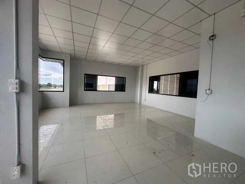 Factory for rent in Wang Noi, Phra Nakhon Si Ayutthaya - Bright office room with tiled floors, drop ceiling, and wide windows overlooking the site.
