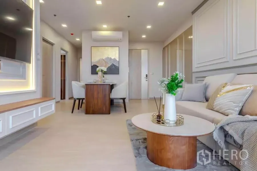 คอนโด ให้เช่าในHuai Khwang, Bangkok - ห้องนั่งเล่นสว่าง โซฟา ผนังบัว ทีวีบิลท์อิน และโต๊ะกลางทรงกลม