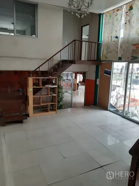 Retail Space for rent in Watthana, Bangkok - Double-height retail lobby with glass storefront doors, tiled floor and a staircase to the mezzanine.