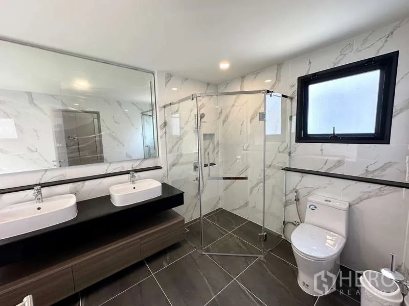 บ้าน ให้เช่าในBang Phli, Samut Prakan - ห้องน้ำสมัยใหม่ อ่างล้างหน้าแบบคู่ ฝักบัวกระจก และผนังลายหินอ่อน