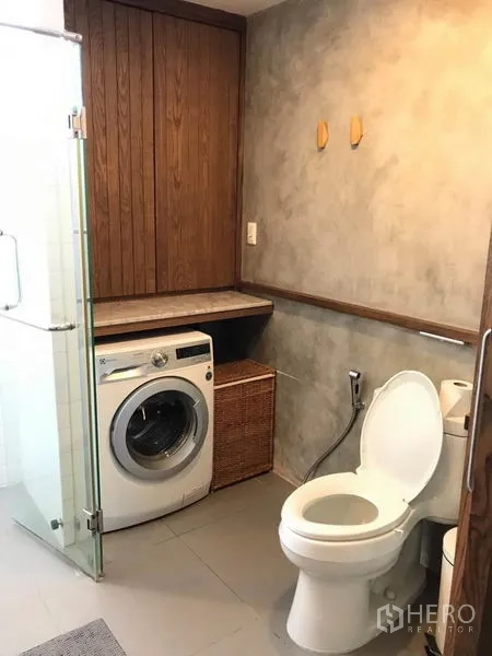 联排别墅 出售在Wang Thonglang, Bangkok - 浴室带玻璃淋浴、坐便和一体式洗衣区（洗衣机）。