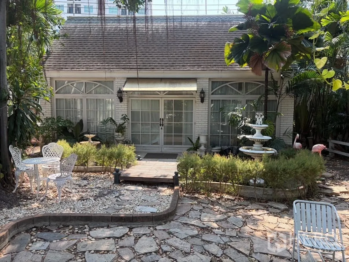 Detached House for rent in Phra Khanong, Bangkok - Cottage-style house front with French windows and a tiered fountain.