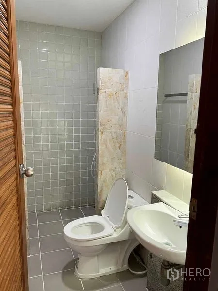 带办公室的家 出租在Bang Kapi, Bangkok - 整洁卫生间，配坐便器、台盆、镜子与瓷砖淋浴区。